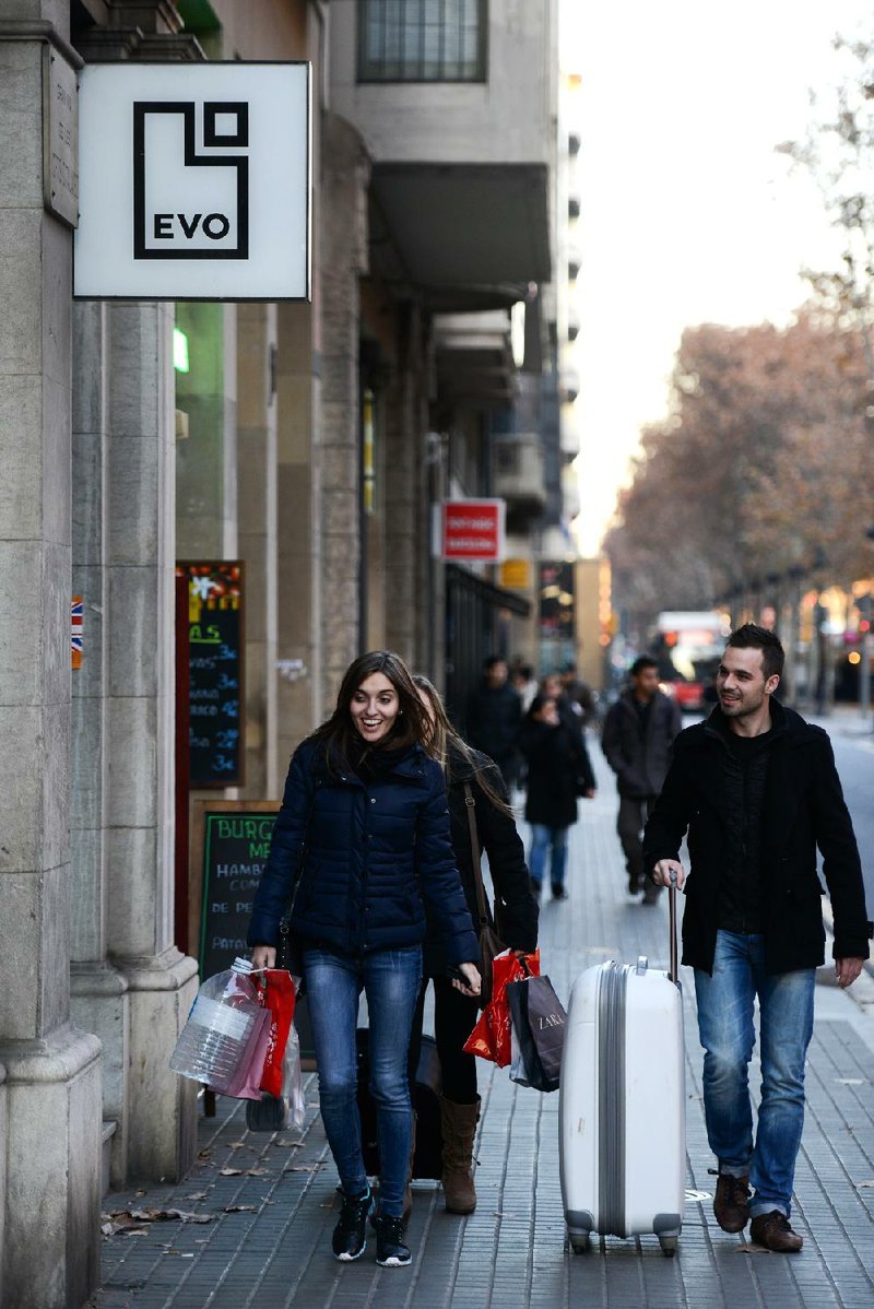 Pedestrians in Barcelona, Spain, pass a bank branch last month. European banks extended fewer loans to companies in November, a sign the continent’s economic recovery remains weak. 