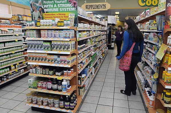 Michaella Hogan, 19, left, and Rebecca Hogan, 15, search for hair growth supplements Friday, Jan. 3, 2014, near cold and flu supplements at Cook's Natural Market in Rogers. Michaella Hogan said she uses Spirulina, a type of blue-green algae, to boost her immune system and prevent sickness.