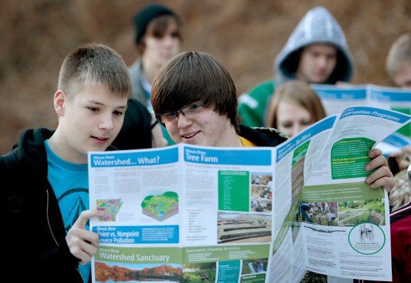 Springdale High sophomore Kage (cq) Stroubel (cq) (left) and senior Chase McDowell look over the watershed map while on a hike in Cave Springs on Friday, Jan. 3, 2014, during a leadership summit for EAST students with the Illinois River Watershed Project.