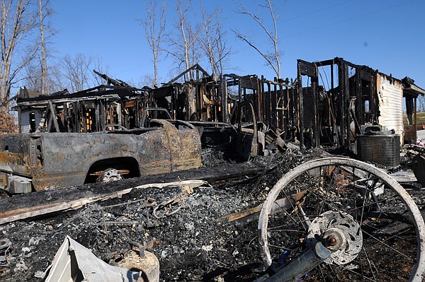 The charred remains of a house located at 10484 Kays Lane soak in the afternoon sun Friday, Jan. 3, 2013, in Rogers. Frankie Elliot, Avoca fire chief, said the residents of the home were in Branson, Mo. at the time of the fire and no one was injured. The cause of the fire is under investigation.