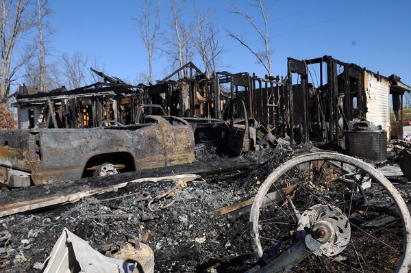 The charred remains of a house located at 10484 Kays Lane soak in the afternoon sun Friday, Jan. 3, 2013, in Rogers. Frankie Elliot, Avoca fire chief, said the residents of the home were in Branson, Mo. at the time of the fire and no one was injured. The cause of the fire is under investigation.