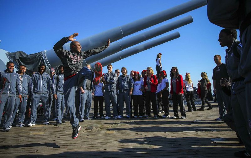 1/4/14
Arkansas Democrat-Gazette/STEPHEN B. THORNTON
Freshman wide receiver Booker Mays takes his turn showing off his best dance moves in a circle of other players and cheerleaders as the horse around on the deck of the USS Alabama battleship during a tour there Saturday in Mobile, Ala.