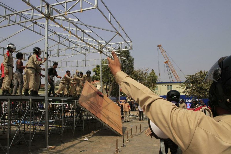 Security personnel remove a shelter where Cambodian National Rescue Party leaders give a speech to their supporters at Democracy Square in Phnom Penh, Cambodia, Saturday, Jan. 4, 2014.  Cambodian police have pushed out about 1,000 anti-government demonstrators from a park in the capital Phnom Penh, a day after four people were killed in a crackdown on a labor protest.  (AP Photo/Heng Sinith)