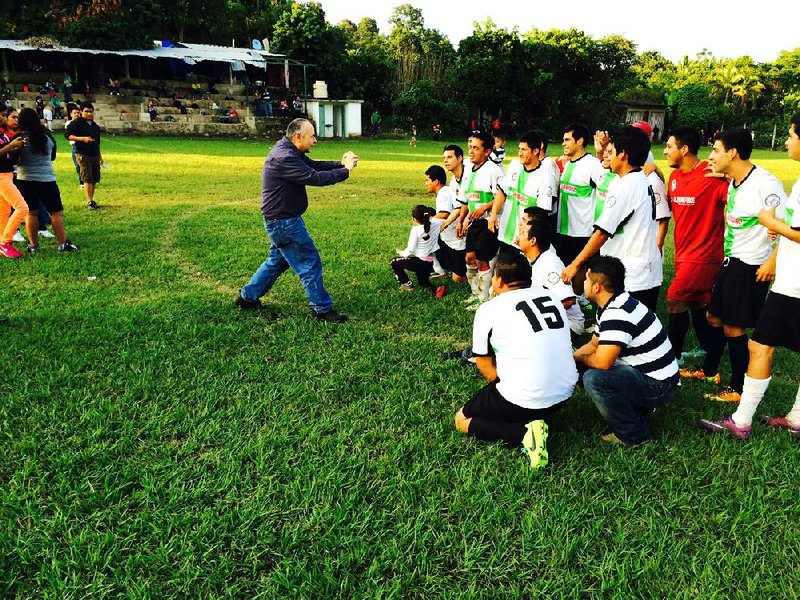 James Judkins photographs the winning team at a carnival workers' soccer tournament on Nov. 12, 2013 in Tlapacoyan, Mexico. Illustrates MEXICO-CARNIVAL (category i), by Joshua Partlow (c) 2014, The Washington Post. Moved Thursday, Jan. 2, 2014. (MUST CREDIT: Washington Post photo by Joshua Partlow)