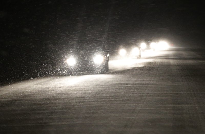 Motorists make their way west as snow begins to build up on U.S. 24 near Belvue, Kan., Saturday, Jan. 4, 2014. The area is under a winter weather advisory and wind chill warning. (AP Photo/Orlin Wagner)