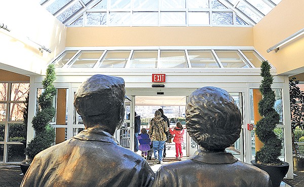 STAFF PHOTO SAMANTHA BAKER 
• @NWASAMANTHA 
Statues of Harvey and Bernice Jones watch people exit Friday at the Center for Nonprofits in Rogers. The center will celebrate its fifth birthday in April. The center hosts 34 nonprofit organizations.