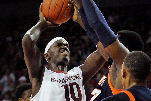 Arkansas' Bobby Portis attempts a shot while being guarded by UT Martin's Pierre Mopo during the first half of the basketball game in Bud Walton Arena in Fayetteville on Thursday December 19, 2013. 
