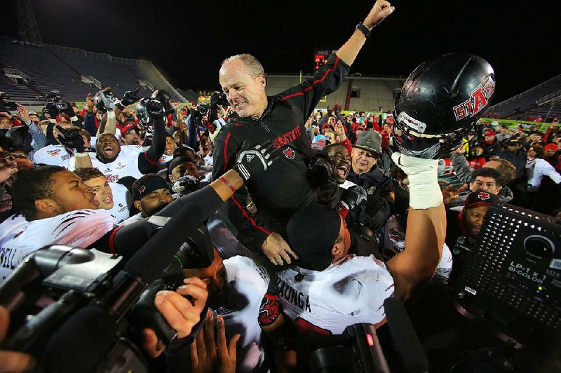 1/5/14
Arkansas Democrat-Gazette/STEPHEN B. THORNTON
Arkansas State University's football team hoist  interim coach John Thompson onto their shoulders after their comeback victory over Ball State University in Sunday's GoDaddy Bowl in Mobile, Ala.