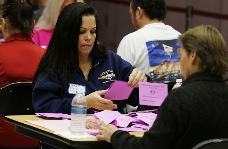 Volunteer vote counters tally ballots Friday, Jan. 3, 2014, at the Boeing Machinists union hall in Seattle. Workers were voting on the Boeing Co.'s latest contract offer to keep the assembly of the Being 777X airplane in Washington state. (AP Photo/Ted S. Warren)