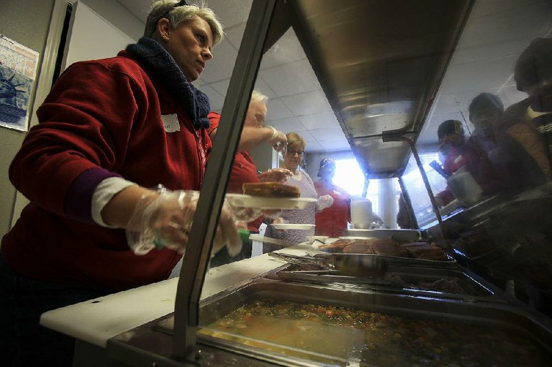  Arkansas Democrat-Gazette/STATON BREIDENTHAL --1/6/14-- Volunteers (left to right) Karen Fagaly, Eddie Stancil, Toby Fair and Toi (cq) Robinson serve lunch Monday afternoon at the Arkansas Dream Center in Little Rock for people staying in the warming center opened by the group. 