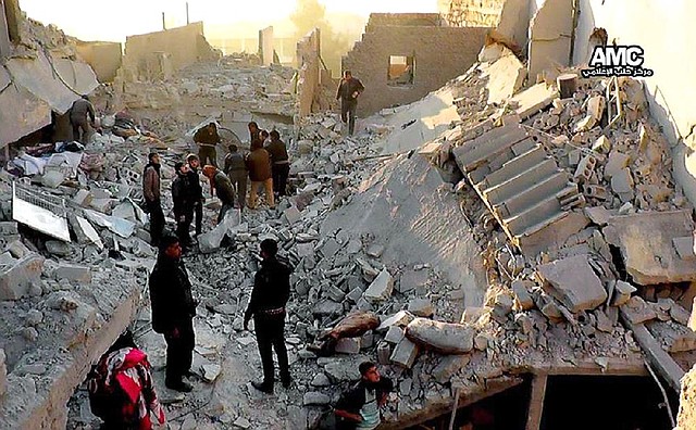 Syrians look through the rubble of destroyed buildings Monday after a Syrian government airstrike in Aleppo, Syria, in this photo provided by the Aleppo Media Center. 