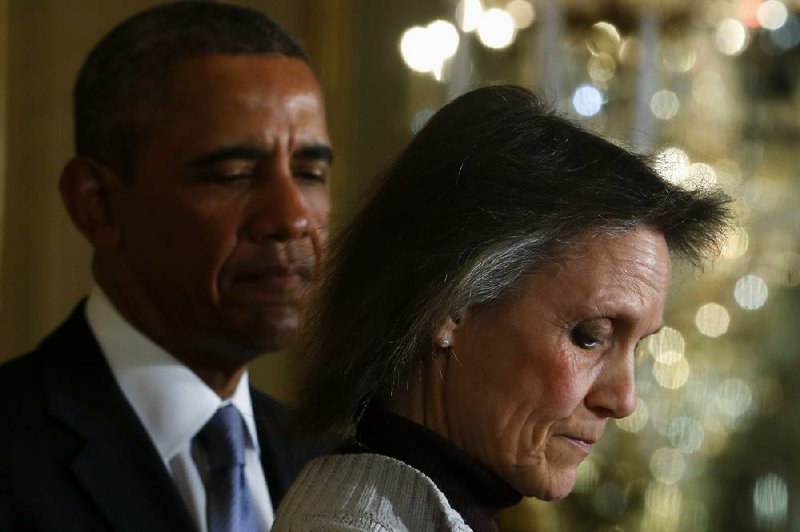 President Barack Obama waits to speak Tuesday at the White House after an introduction by Katherine Hackett of Moodus, Conn., who wrote to the president about her dependence on unemployment benefits while trying to find a job. Obama praised her “strength and dignity.” 