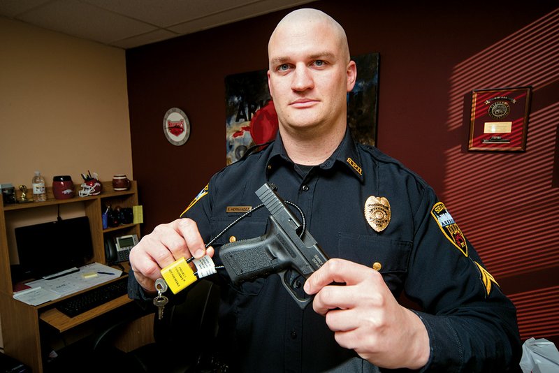 Steve Hernandez, public information officer for the Searcy Police Department, shows one of the free Project ChildSafe gun locks installed on a pistol.

