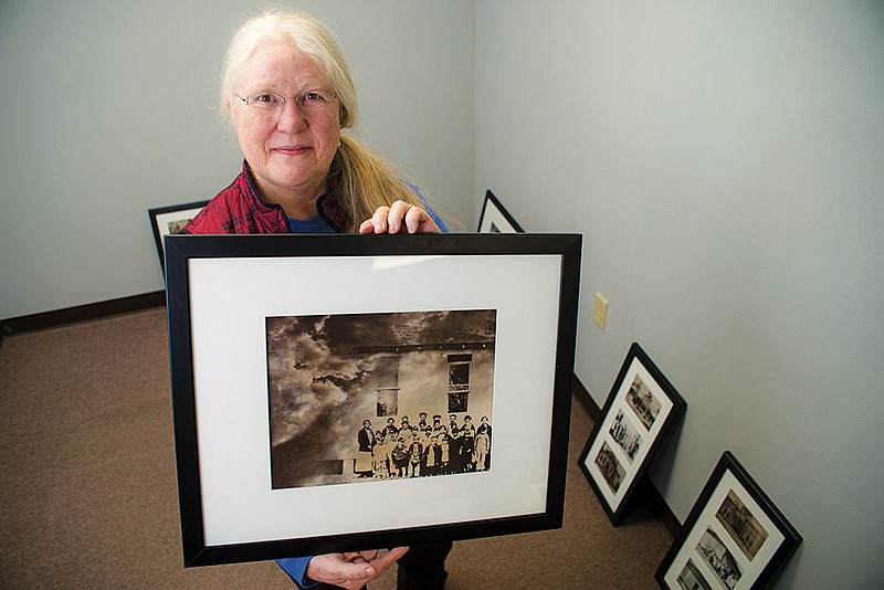 Beverly Buys holds one of the photos from the exhibition Sometimes All That Remains Are Visions and Dreams: School Days in Clark County, Arkansas (1920-1930), a series of prints created by photographer and artist Rhonda Berry utilizing images from large-format negatives of Clark County Schools that are a part of the Jane Ross Photographic Archive, which is housed at Henderson State University in Arkadelphia.