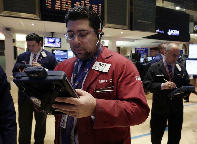 Michael Capolino (front) works with fellow traders Wednesday on the floor of the New York Stock Exchange. 