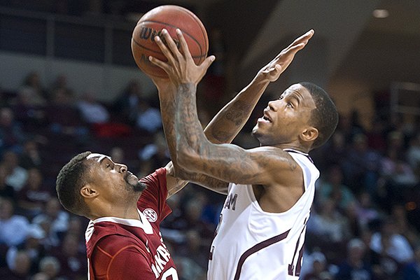 Texas A&M's Fabyon Harris, right, jumps to the hoop against Arkansas' Rahsad Madden during the first half of an NCAA college basketball game in College Station, Texas, Wednesday, Jan. 8, 2014. (AP Photo/Bryan College Station Eagle, Stuart Villanueva)