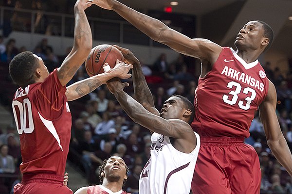 Arkansas' Rashad Madden, left, and Moses Kingsley (33) block the shot of Texas A&M's Shawn Smith during the first half of an NCAA college basketball game in College Station, Texas, Wednesday, Jan. 8, 2014. (AP Photo/Bryan College Station Eagle, Stuart Villanueva)
