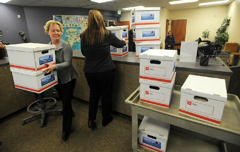 Katrin Haugh, left, and Carol Thompson, of the Absentee and Petition Office, begin processing 20 boxes of over 46,000 signatures for a proposed ballot initiative to legalize recreational use of marijuana in Alaska, on Wednesday, Jan. 8, 2014, at the state Division of Elections office in Anchorage, Alaska.  If enough signatures are verified — they need about 30,000 qualified signatures — the question of whether to make pot legal in the nation's northernmost state will go before voters in the Aug. 19 primary. Signatures must come from at least 7 percent of voters in at least 30 House districts. (AP Photo/The Anchorage Daily News, Erik Hill)  LOCAL TV OUT (KTUU-TV, KTVA-TV) LOCAL PRINT OUT (THE ANCHORAGE PRESS, THE ALASKA DISPATCH)