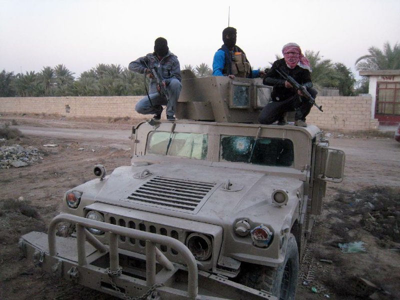 Gunmen sit on top of an Iraqi army Humvee, left by Iraqi soldiers during clashes in Fallujah, 40 miles (65 kilometers) west of Baghdad, Iraq, Thursday, Jan. 9, 2014. Tribal leaders in Fallujah have warned al-Qaida fighters there to leave to avoid a military showdown, and there were signs that residents of Fallujah were trying to restore a sense of normalcy, however precarious. (AP Photo)