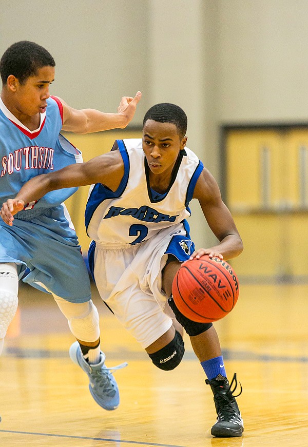 Xavier Smith of the Mounties brings the ball into the paint as Christian McKinney of the Rebels of Ft. Smith  at Arvest Hoopfest Saturday, December 14, 2013 at Rogers High King Arena