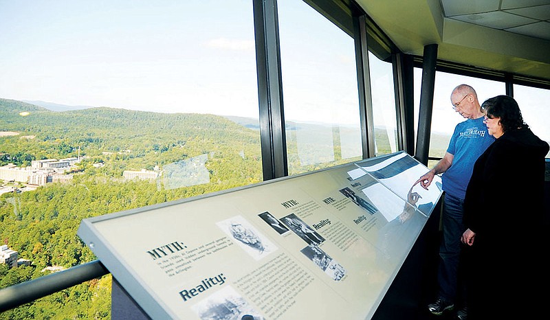 Ron and Ramona Thompson of Dallas read informative signs at the Hot Springs Mountain Tower on Oct. 17. The tower is currently being operated by the Hot Springs Advertising and Promotion Commission under an extension of a contract that was previously set to expire at the end of 2013.
