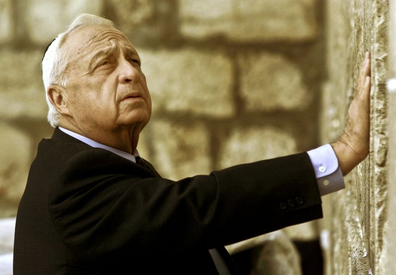 In this Wednesday Feb. 7, 2001 file photo, Ariel Sharon, then Israel's Prime Minister-elect, looks up as he touches Judaism holiest site, the Western Wall, in Jerusalem. The son of former Israeli Prime Minister Ariel Sharon says his father has died on Saturday, Jan. 11, 2014. The 85-year-old Sharon had been in a coma since a debilitating stroke eight years ago. (AP Photo/David Guttenfelder, File)