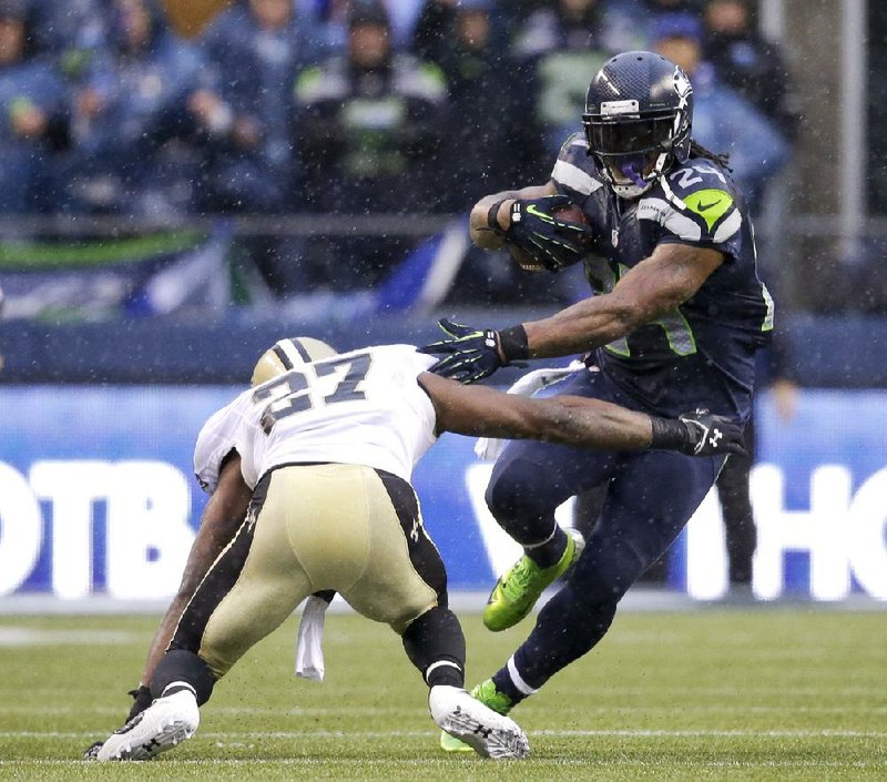 Seattle running back Marshawn Lynch avoids a tackle by New Orleans’ Malcolm Jenkins in the first half of the Seahawks’ 23-15 victory Saturday. Lynch rushed for 140 yards and scored twice. 