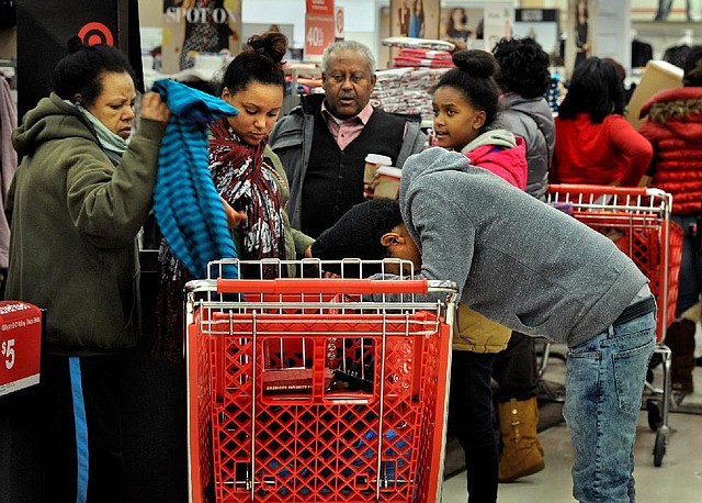 Steve Tefru, 18, rests his head on a shopping cart as members of his family go through items looking for low prices on Thursday evening at the Target store in Washington&apos;s Columbia Heights area. Hundreds of shoppers already were in line when the store opened its doors 8 p.m. Thursday. Illustrates BLACKFRIDAY (category f), by Sarah Halzack and Jeremy Borden (c) 2013, The Washington Post. Moved Friday, Nov. 29, 2013.  (MUST CREDIT: Washington Post photo by Michael S. Williamson)