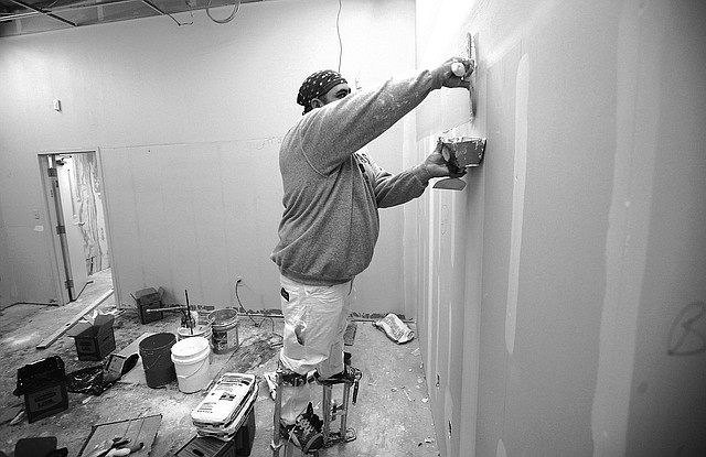 STAFF PHOTO JASON IVESTER Alvaro Ramirez with Laxen Painting works Wednesday on the renovation at the former USA Drug building on West Walnut Street in Rogers. The work is being done for the new Benton County offices for the Assessor, Collector and County Clerk, along with the state Revenue Office.