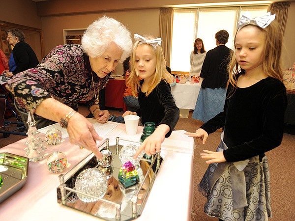 Mary Frances Maestri Vaughan of Springdale, left, shows her collection of paperweights to Blue Barley, 5, center, and her sister Mary Jane Barley, 8, both of Farmington during the annual Cabin Fever Reliever Saturday, Jan. 11, 2014, at the Shiloh Museum of Ozark History in Springdale. The museum hosted 23 local patrons and their collections and held drawings for tours of its collections in the museum basement for participants.