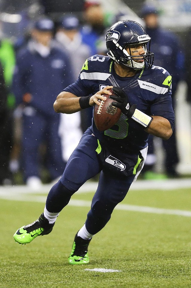Seattle Seahawks quarterback Russell Wilson rolls out during the second half of an NFC divisional playoff NFL football game against the New Orleans Saints in Seattle, Saturday, Jan. 11, 2014. (AP Photo/Ted S. Warren)