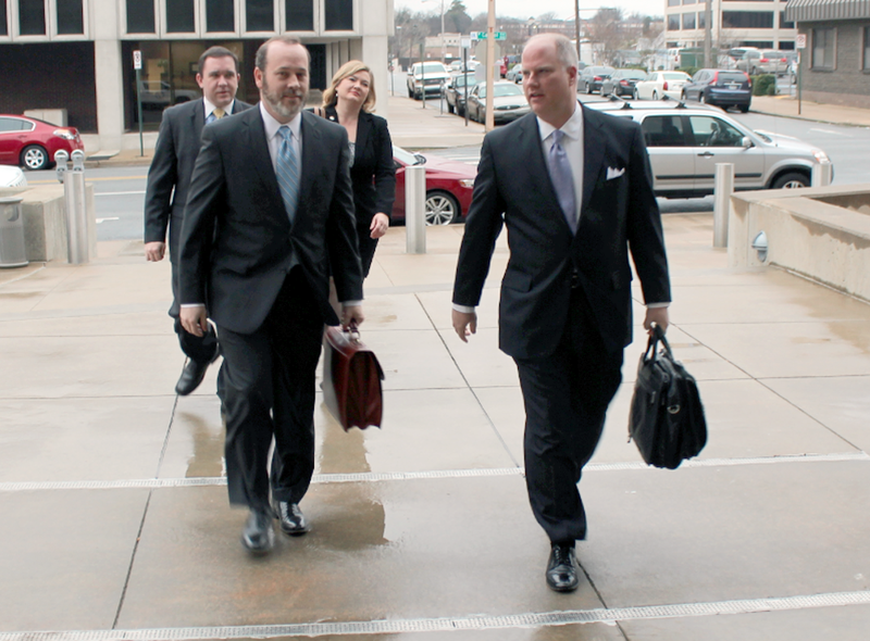 Arkansas Attorney General Dustin McDaniel, right, and staff members arrive Monday, Jan. 13, 2014, at a fairness hearing over an agreement to phase out millions in annual desegregation aid paid by the state to three Pulaski County school districts.