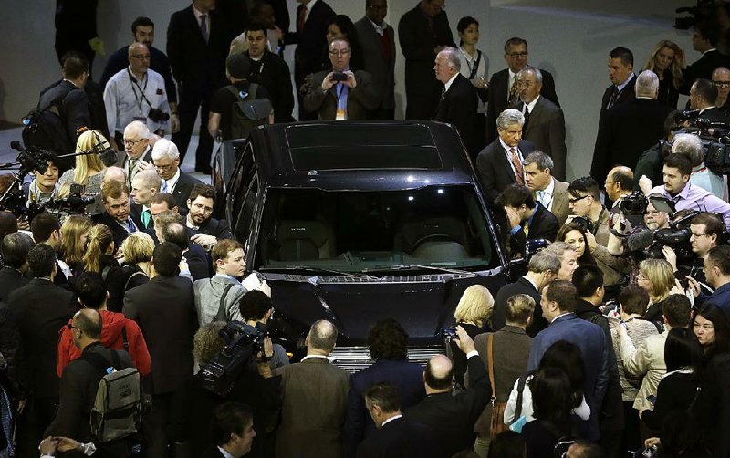 Journalists surround the new F-150 with a body built almost entirely out of aluminum at the North American International Auto Show in Detroit, Monday, Jan. 13, 2014. (AP Photo/Carlos Osorio)