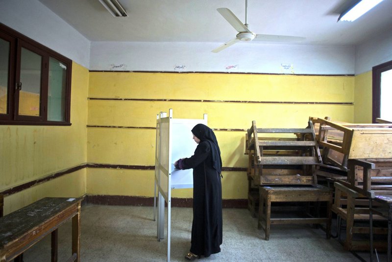 An Egyptian woman votes in the country's constitutional referendum in Cairo on Tuesday, Jan. 14, 2014. Military helicopters buzzed overhead and hundreds of thousands of soldiers and police were deployed as Egyptians voted Tuesday on a new constitution in a referendum that will pave the way for a likely presidential run by the nation's top general months after he ousted Islamist President Mohammed Morsi.