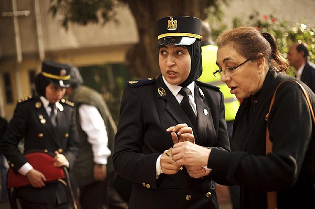 A police officer directs a woman at a polling site Tuesday in Cairo as voting got under way on a constitutional referendum. 