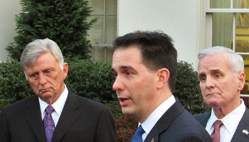 Arkansas Gov. Mike Beebe (left) and Minnesota Gov. Mark Dayton (right) listen Tuesday as Wisconsin Gov. Scott Walker speaks with reporters outside the White House. The three were among a group of governors who met with President Barack Obama and discussed the health-care overhaul. 
