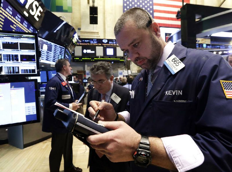 Trader Kevin Lodewick (right) works Tuesday on the floor of the New York Stock Exchange. A positive retail sales report and growth in technology stocks led to index gains Tuesday, analysts said. 