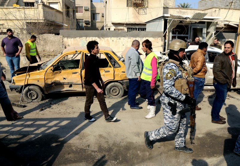 Civilians and security forces gather at the site of a car bomb attack near the Technology University in Sinaa Street in downtown Baghdad on Wednesday, Jan. 15, 2014. A wave of bombings across Iraq striking busy markets and a funeral north of Baghdad killed tens of people Wednesday, authorities said, as the country remains gripped by violence after al-Qaida-linked militants took control of two cities in western Anbar province. 