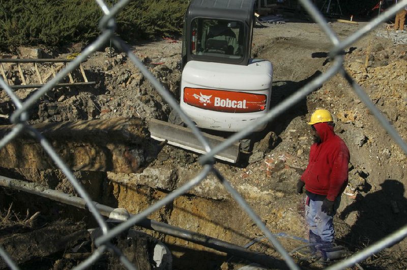 James Turner and other construction workers dig up materials, including a pre-Civil War-era sword, from former buildings at a job site in Little Rock’s River Market District. 