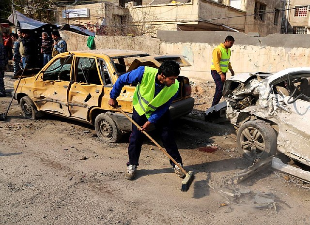 Baghdad city workers clean up Wednesday after a car-bomb attack, one of several in the Iraqi capital that killed at least 28 people. Also Wednesday, militants who seized a town near Fallujah were routed in an air and ground attack that marked a rare victory for government forces struggling to regain control of the area.