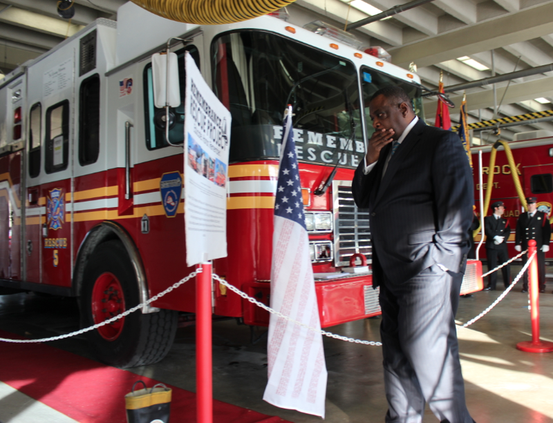 Little Rock Fire Department Chief Greg Summers reads information alongside a New York Fire Department rescue unit that responded to the Sept. 11, 2001 attacks. The unit, a mobile memorial, is in Little Rock through next week.