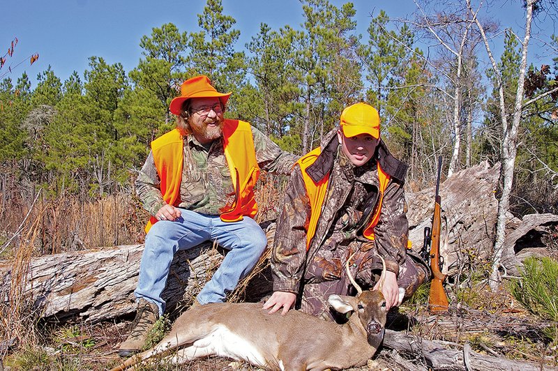 Keith, left, and Zach Sutton of Alexander pose for a photo in 2006 after 15-year-old Zach killed this spike buck. The father and son have many good memories of hunting together from a friend’s deer stand.