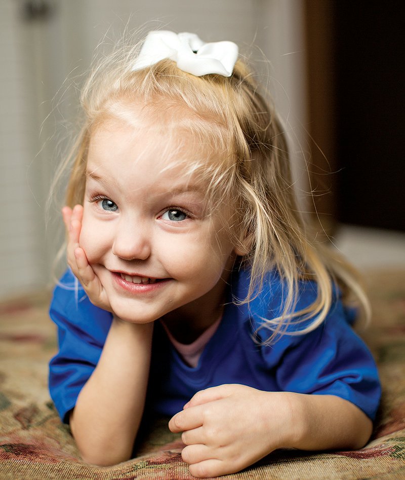 Zoey Dillon, 3, of Conway lies on the floor at her home. Zoey has a genetic disorder, spinal muscular atrophy type 2, that causes severe problems for her motor neurons, resulting in muscle weakness. She can’t walk, but she can crawl by using her arms and loves to operate her electric wheelchair. Her family is trying to raise money to buy a used wheelchair-accessible van.