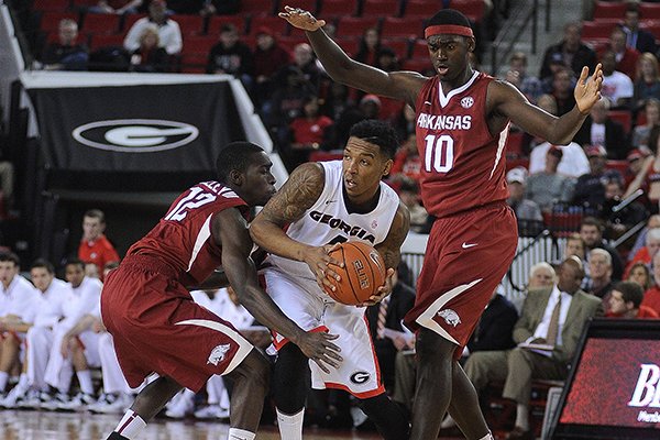 Georgia guard Charles Mann (4) is double-teamed by Arkansas forward Bobby Portis (10) and guard Fred Gulley III (12) during the first half of an NCAA college basketball game Saturday, Jan. 18, 2014, in Athens, Ga. (AP Photo/The Banner-Herald, Richard Hamm)