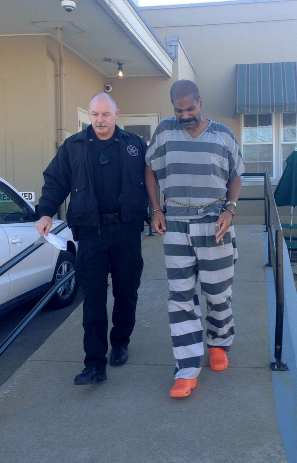 Perry Dennis Davis Jr., 50, of Bentonville is escorted Friday morning  by a sheriff's deputy to a patrol car after a hearing in his murder case. Davis is accused of killing his wife. A judge ordered Davis to have his blood drawn for medical testing due to concern about Davis' weight loss.