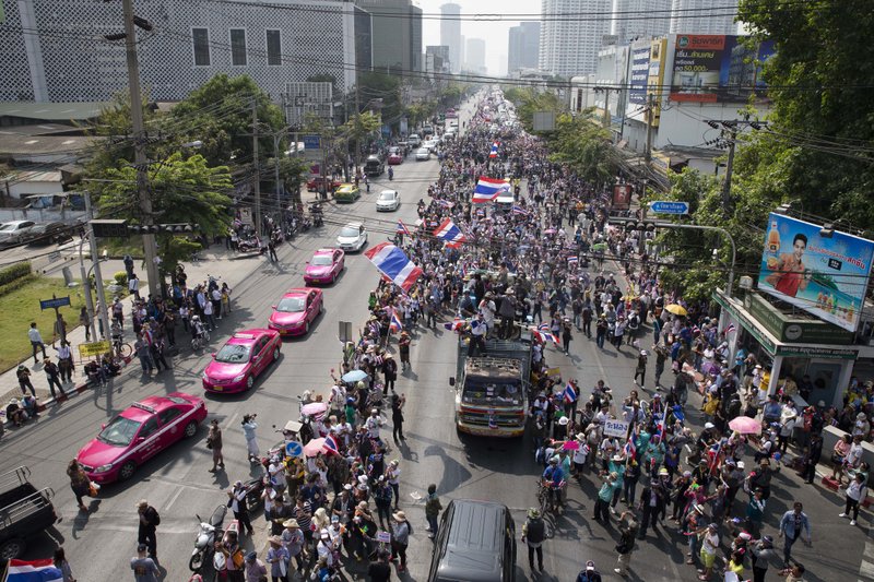 Anti-government protesters block traffic during a march, Sunday, Jan. 19, 2014, in Bangkok. Two explosions shook an anti-government demonstration site in Thailand's capital on Sunday, wounding at least 28 people in the latest violence to hit Bangkok as the nation's increasingly volatile political crisis drags on. (AP Photo/John Minchillo)