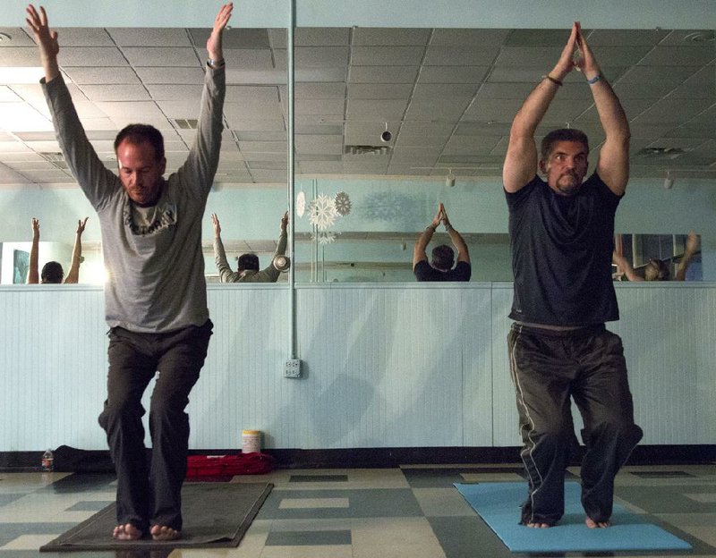 Arkansas Democrat-Gazette/BENJAMIN KRAIN --1/15/2014--
Roger Neal, left, and Patrick Presley are among a small group of men who participate in a yoga class at Blue Yoga Nyla in North Little Rock. 