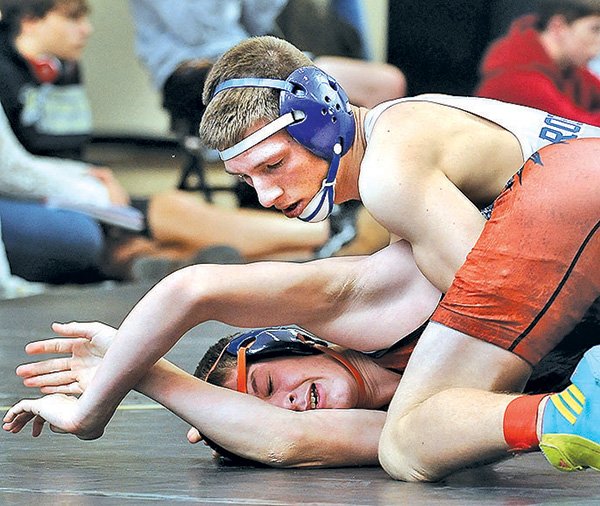 STAFF PHOTO BEN GOFF 
Heath Henman of Rogers High, top, works to pin Heritage’s Gaven Long during the 132-pound final on Saturday at the Bentonville Tiger Classic wrestling tournament. Henman won the match by pinning Long.