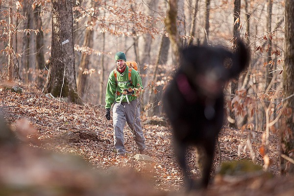 Arkansas Democrat-Gazette/RYAN McGEENEY 
Kristian Underwood of Winslow treks Wednesday morning along the Ozark Highlands Trail near Cass with his dog, Tiggie. Underwood, a professional cartographer, is producing the first map updates in decades for the Ozark trail and the Mulberry River.