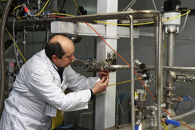 An unidentified International Atomic Energy Agency (IAEA) inspector cuts the connections between the twin cascades for 20 percent uranium enrichment at the Natanz facility, some 200 miles (322 kilometers) south of the capital Tehran, Iran, Monday, Jan. 20, 2014. Iran has halted its most sensitive uranium enrichment work as part of a landmark deal struck with world powers, state TV said Monday. The broadcast said Iran halted its 20 percent uranium enrichment, which is just steps away from bomb-making materials, by cutting the link feeding cascades enriching uranium in Natanz. (AP Photo/IRNA, Kazem Ghane)